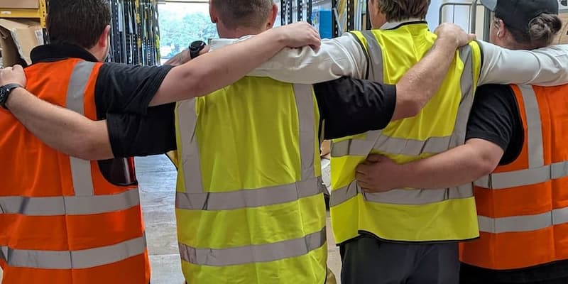 four men wearing different hi-vis classess and colours